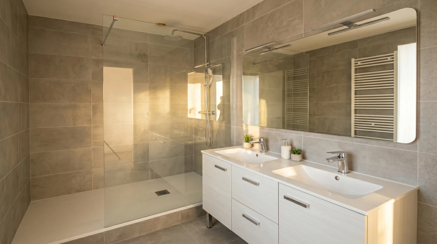 Salle de bain moderne luxueuse avec douche à l'italienne vitrée, baignoire d'angle encastrée, double vasque sur meuble suspendu blanc